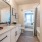 Southeast Austin Apartments for Rent - Ariza Easton Park - Bathroom with Granite-Style Sink, Shower and Bathtub Combined, and Large Mirror