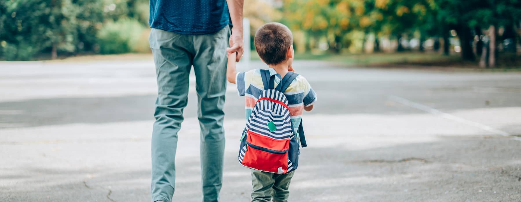 lifestyle image of a person walking with their child outside
